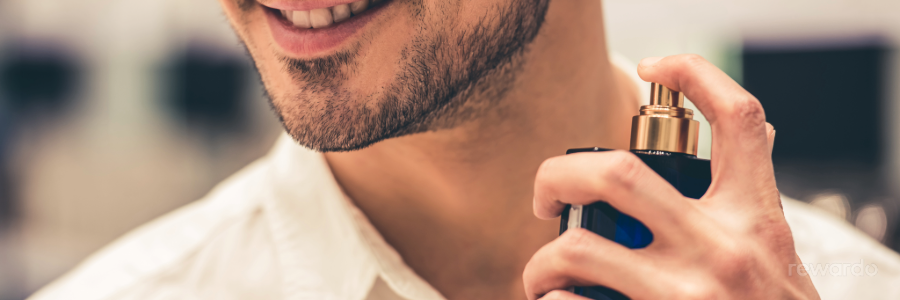 Beauty - Mann sprüht Parfum an seinen Hals